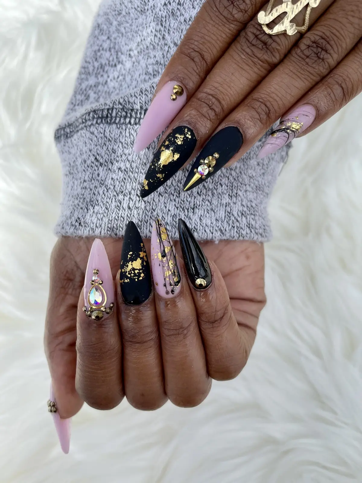 Detailed black, gold, and pink nail art